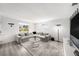 Bright living room featuring gray sectional sofa, stylish lamp, and modern entertainment center at 4521 W North St, Tampa, FL 33614