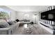 Bright living room featuring gray sectional sofa, stylish lamp, and modern entertainment center at 4521 W North St, Tampa, FL 33614