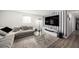 Spacious living room featuring a comfortable gray couch, modern lighting, and sleek entertainment center at 4521 W North St, Tampa, FL 33614