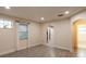 Bright living room with wood-look tile floors, large windows, and an arched doorway leading to the bathroom at 4611 17Th N Ave, St Petersburg, FL 33713