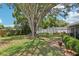 Expansive backyard featuring lush green grass, large shade trees, storage sheds, and landscaping at 512 Hillpine Way, Brandon, FL 33510