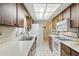 Galley kitchen featuring wood cabinetry, white appliances, and tiled floors and backsplash at 512 Hillpine Way, Brandon, FL 33510