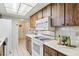 Cozy kitchen featuring wood cabinets, white appliances, and tile flooring and backsplash at 512 Hillpine Way, Brandon, FL 33510