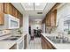 Galley kitchen open to the dining area, featuring wood cabinets, and white appliances at 512 Hillpine Way, Brandon, FL 33510