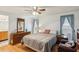 Bright main bedroom features a ceiling fan, wood floors, and ensuite bathroom at 512 Hillpine Way, Brandon, FL 33510