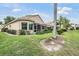 Rear exterior showcasing a beige house, screened patio and well-maintained landscaping at 5156 Pinnacle Dr, Oldsmar, FL 34677