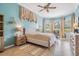 Well-lit bedroom features bay windows, blue walls, ceiling fan, and neutral tones at 5156 Pinnacle Dr, Oldsmar, FL 34677