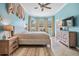 Bright bedroom features large windows, blue walls, ceiling fan, and neutral tones at 5156 Pinnacle Dr, Oldsmar, FL 34677