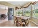 Bright breakfast nook featuring a rustic dining table, elegant drapery, and sliding doors to the outside patio at 5156 Pinnacle Dr, Oldsmar, FL 34677