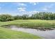 Scenic view of a lush green golf course with a pond on a sunny day at 5156 Pinnacle Dr, Oldsmar, FL 34677