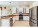 Spacious kitchen with stainless steel appliances, white cabinetry, granite countertops, and designer pendant lighting at 5156 Pinnacle Dr, Oldsmar, FL 34677