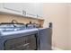 Modern laundry room with new front load washer and dryer with cabinets above at 5156 Pinnacle Dr, Oldsmar, FL 34677