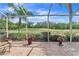 Screened in lanai with tiled floor and scenic views of lush green landscape and blue skies at 5156 Pinnacle Dr, Oldsmar, FL 34677