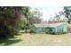 Quaint ranch-style house with lovely landscaping, complemented by a green lawn at 5287 Azalea Cir, Dade City, FL 33523