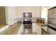 Well-equipped kitchen with stainless steel appliances, white cabinets, and a window overlooking the backyard at 5287 Azalea Cir, Dade City, FL 33523