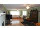 Bright living room with hardwood floors, white sofas, a fireplace, and a dining table set with green chairs at 5287 Azalea Cir, Dade City, FL 33523