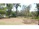 View of treed property grounds; a quaint house is visible in the distance at 5287 Azalea Cir, Dade City, FL 33523