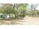 The grounds feature scattered trees, a grassy lawn, and a house set back from the road at 5287 Azalea Cir, Dade City, FL 33523