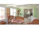 Inviting sunroom with comfortable wicker furniture, tiled floors, and sliding glass door at 5287 Azalea Cir, Dade City, FL 33523