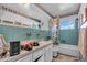 Bathroom with turquoise tiles, a large mirror, window and tub with a shower curtain at 5713 Shore S Blvd, Gulfport, FL 33707