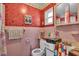 Vintage pink bathroom with a combination tub and shower, window, and cabinet sink at 5713 Shore S Blvd, Gulfport, FL 33707