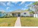 Charming one-story home with a well-manicured lawn and a brick walkway leading to a covered porch at 5713 Shore S Blvd, Gulfport, FL 33707