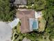 Aerial view of a home with mature landscaping, a pool, and a circular driveway at 60 Lakeview Ct, Palm Harbor, FL 34683