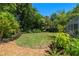 Large backyard features tropical landscaping and a cozy outdoor space for entertaining at 60 Lakeview Ct, Palm Harbor, FL 34683