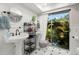 Bright bathroom with dual sinks, stylish fixtures, and a large window with a view of lush outdoor greenery at 60 Lakeview Ct, Palm Harbor, FL 34683