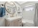 Charming bathroom featuring a vanity with drawers, a gold faucet, a round mirror, and a shower at 60 Lakeview Ct, Palm Harbor, FL 34683