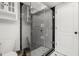 Bathroom with a modern glass-enclosed shower, white tiled walls, and black trim at 60 Lakeview Ct, Palm Harbor, FL 34683