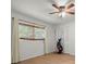 Bright bedroom with a ceiling fan, window with blinds, and a closet with louvered doors at 60 Lakeview Ct, Palm Harbor, FL 34683