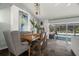 Elegant dining area adjacent to living room showcasing an art piece and providing pool views through screened windows at 60 Lakeview Ct, Palm Harbor, FL 34683