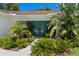 Landscaped front entrance with vibrant plants and stylish double doors, creating a welcoming approach at 60 Lakeview Ct, Palm Harbor, FL 34683