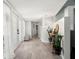 Bright hallway featuring light wood floors, elegant lighting fixtures, and tasteful decor at 60 Lakeview Ct, Palm Harbor, FL 34683