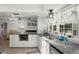 Well-lit kitchen showcasing granite countertops, white cabinets, stainless steel appliances, and stylish pendant lighting at 60 Lakeview Ct, Palm Harbor, FL 34683