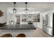Modern kitchen boasts stainless steel appliances, an island, pendant lighting, and open shelving at 60 Lakeview Ct, Palm Harbor, FL 34683