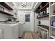 A spacious laundry room boasts open shelving, a folding table, and new washer and dryer at 60 Lakeview Ct, Palm Harbor, FL 34683