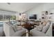 Cozy living room featuring neutral colors, built-in bookshelves, and a view of the screened-in pool at 60 Lakeview Ct, Palm Harbor, FL 34683