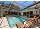 Inviting screened-in pool area with lounge chairs, plants, and seating, perfect for relaxation and entertainment at 60 Lakeview Ct, Palm Harbor, FL 34683