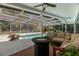 Relaxing covered pool patio with comfortable seating and a sleek fire pit table at 60 Lakeview Ct, Palm Harbor, FL 34683