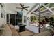Covered pool patio features a lounge area with tv, ceiling fan, and fire pit at 60 Lakeview Ct, Palm Harbor, FL 34683