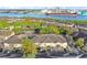 Scenic aerial view of townhomes, a tennis court, and the waterway beyond the lush trees in the Island Walk community at 612 Arbor Lake Ln, Tampa, FL 33602