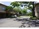 Exterior view of townhome with private parking and lush landscaping, nestled among mature trees for serene living at 612 Arbor Lake Ln, Tampa, FL 33602
