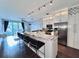 Modern open-concept kitchen with island seating, stainless appliances, and a view to the living room and balcony at 612 Arbor Lake Ln, Tampa, FL 33602