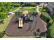 Community playground with a slide, climbing area, and safety mulch surrounded by grass and trees at 612 Arbor Lake Ln, Tampa, FL 33602