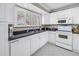Well-lit kitchen with white cabinets, appliances, and countertops at 6309 Newtown Cir # 9B2, Tampa, FL 33615