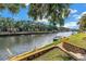 Peaceful waterfront view with lush green landscaping, showcasing waterfront living with dock access for boats and watersport activities at 6309 Newtown Cir # 9B2, Tampa, FL 33615