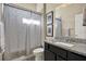 Cozy bathroom featuring a granite-topped vanity and shower with neutral colored curtain at 6909 Crestpoint Dr, Apollo Beach, FL 33572