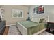 A well-lit bedroom with a white platform bed, green bedding and pictures on the wall at 6909 Crestpoint Dr, Apollo Beach, FL 33572